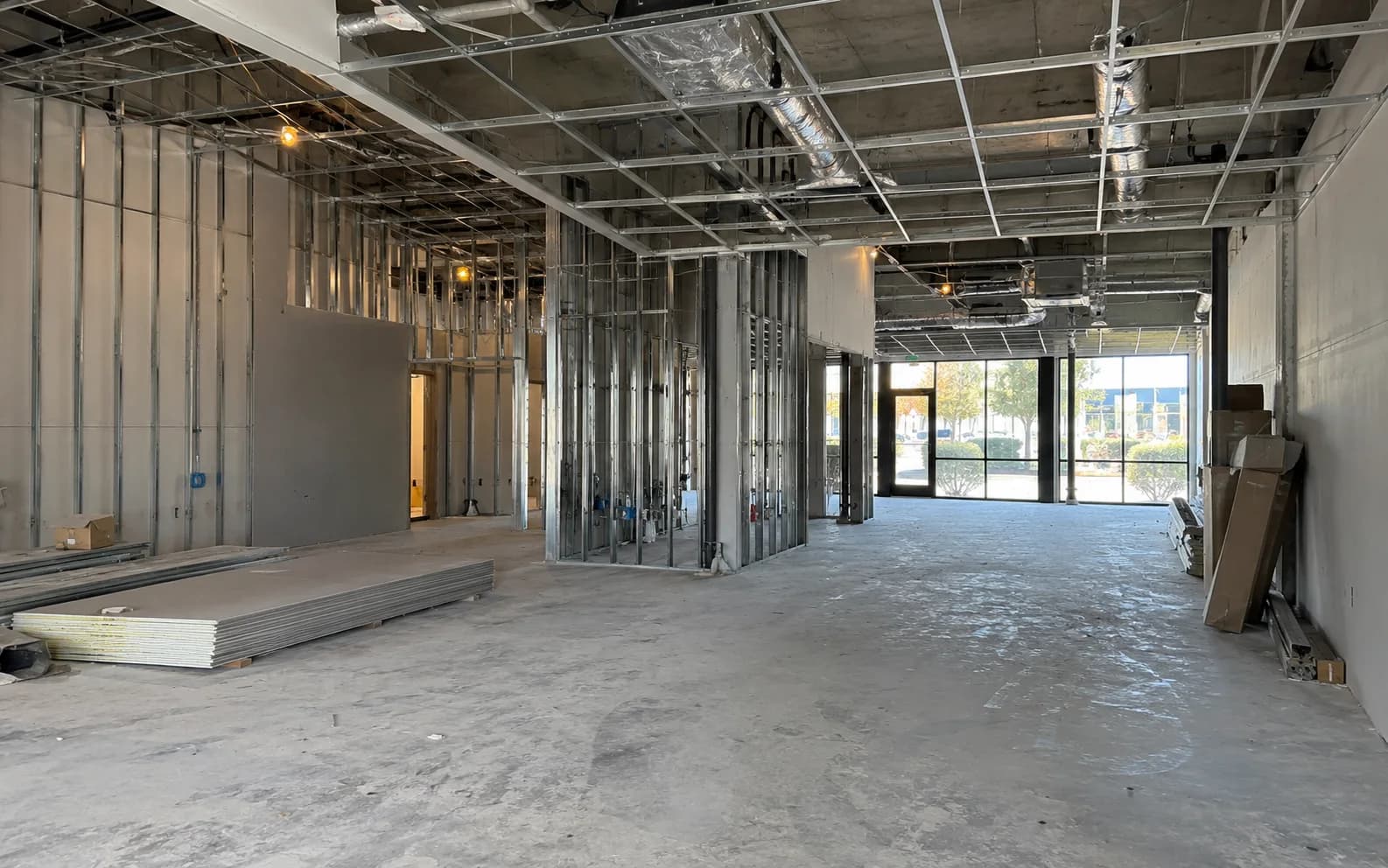 Commercial tenant space with metal stud framing, ceiling rough-in and materials during interior build-out