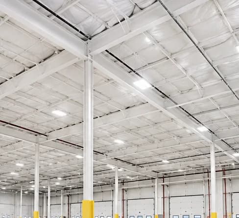 Bright warehouse interior with white-painted ceiling and steel